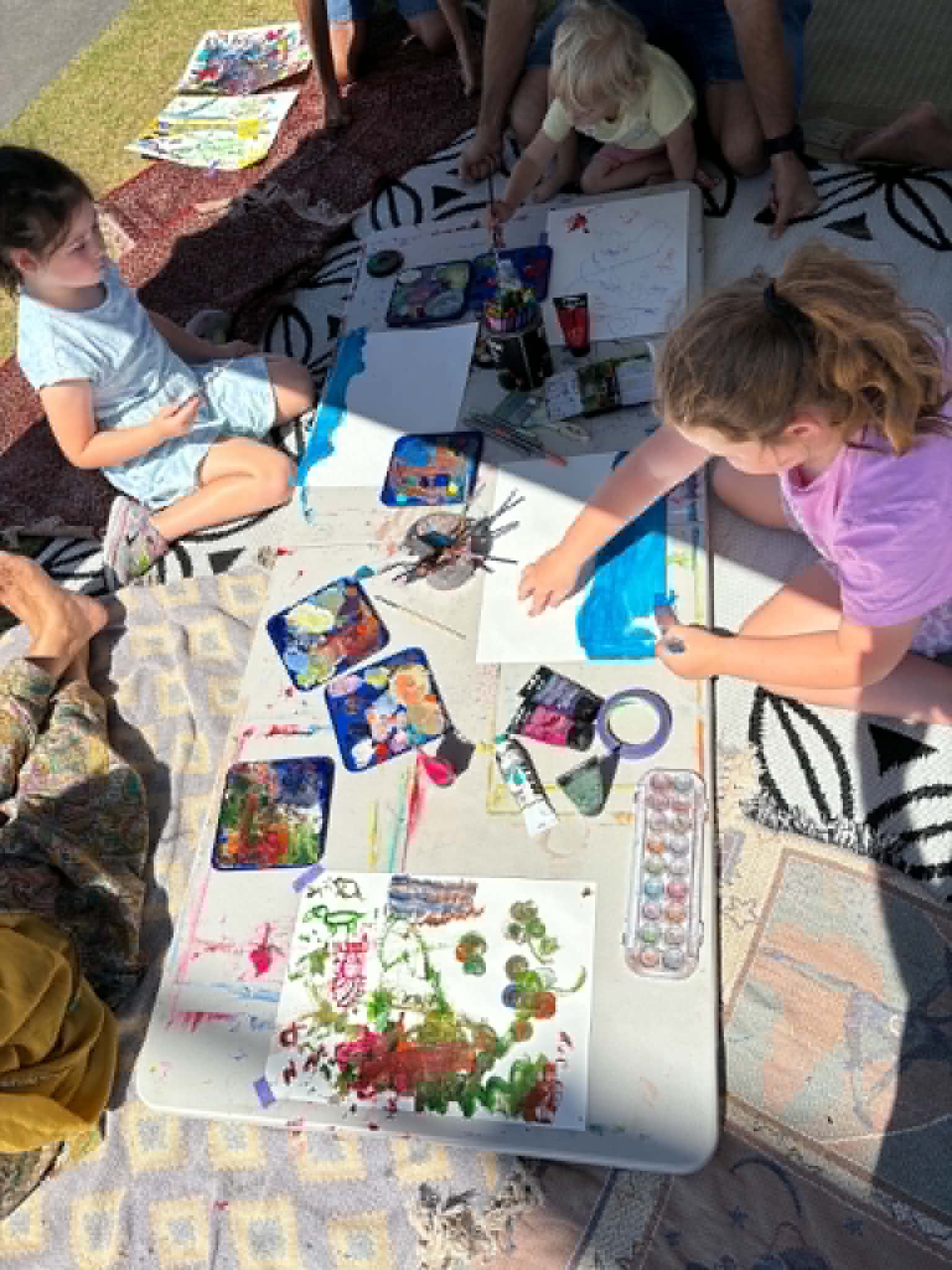 Children creating art together on blankets