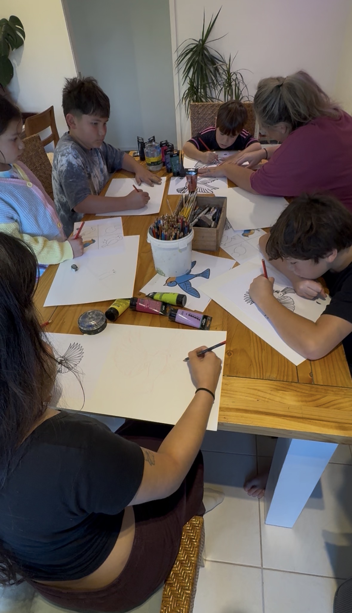 Group of children drawing birds together at a workshop table