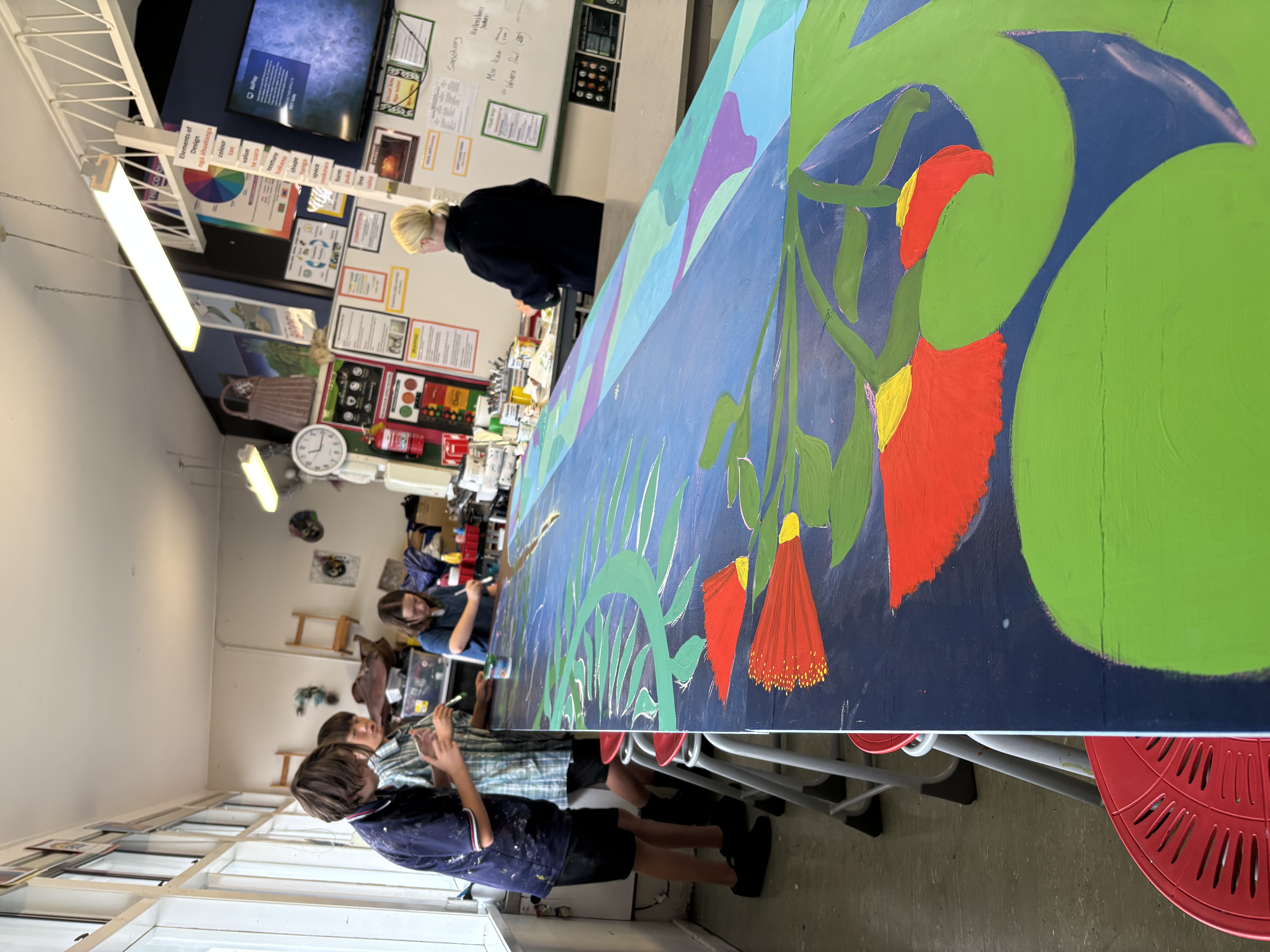 Students painting a school mural on an outdoor water tank