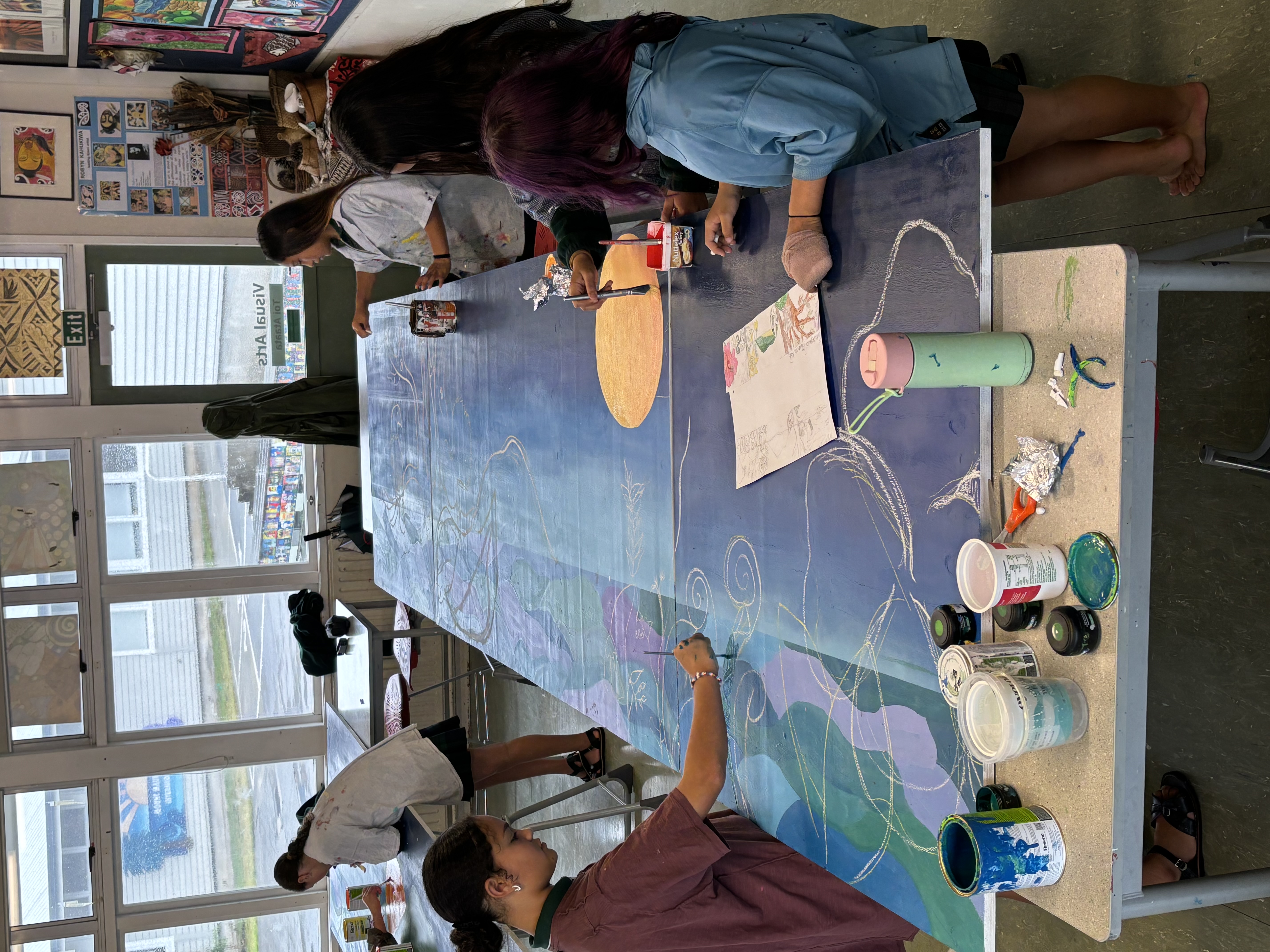 Students collaborating on a colorful school mural
