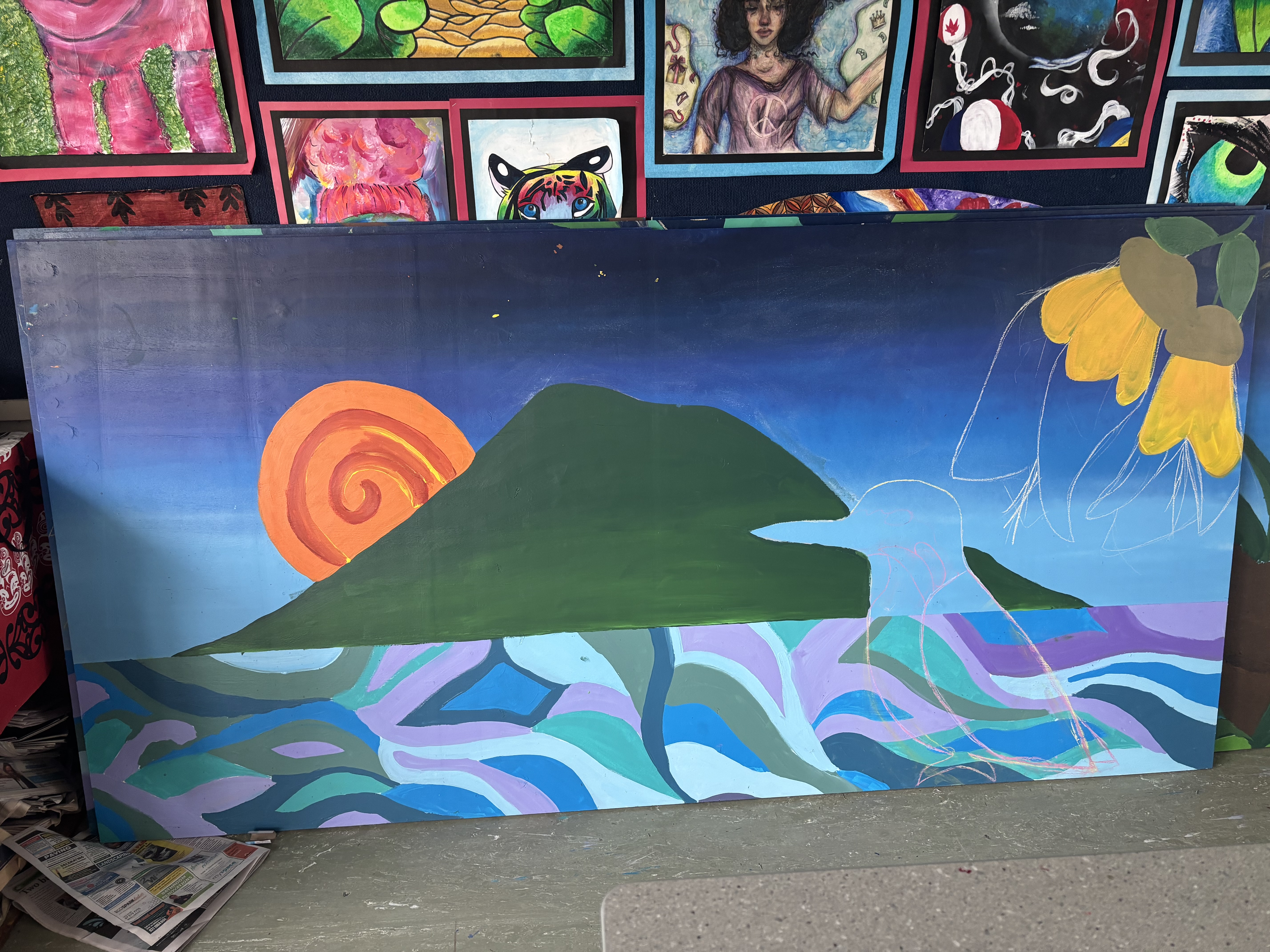 Students painting flowers and nature on a school mural
