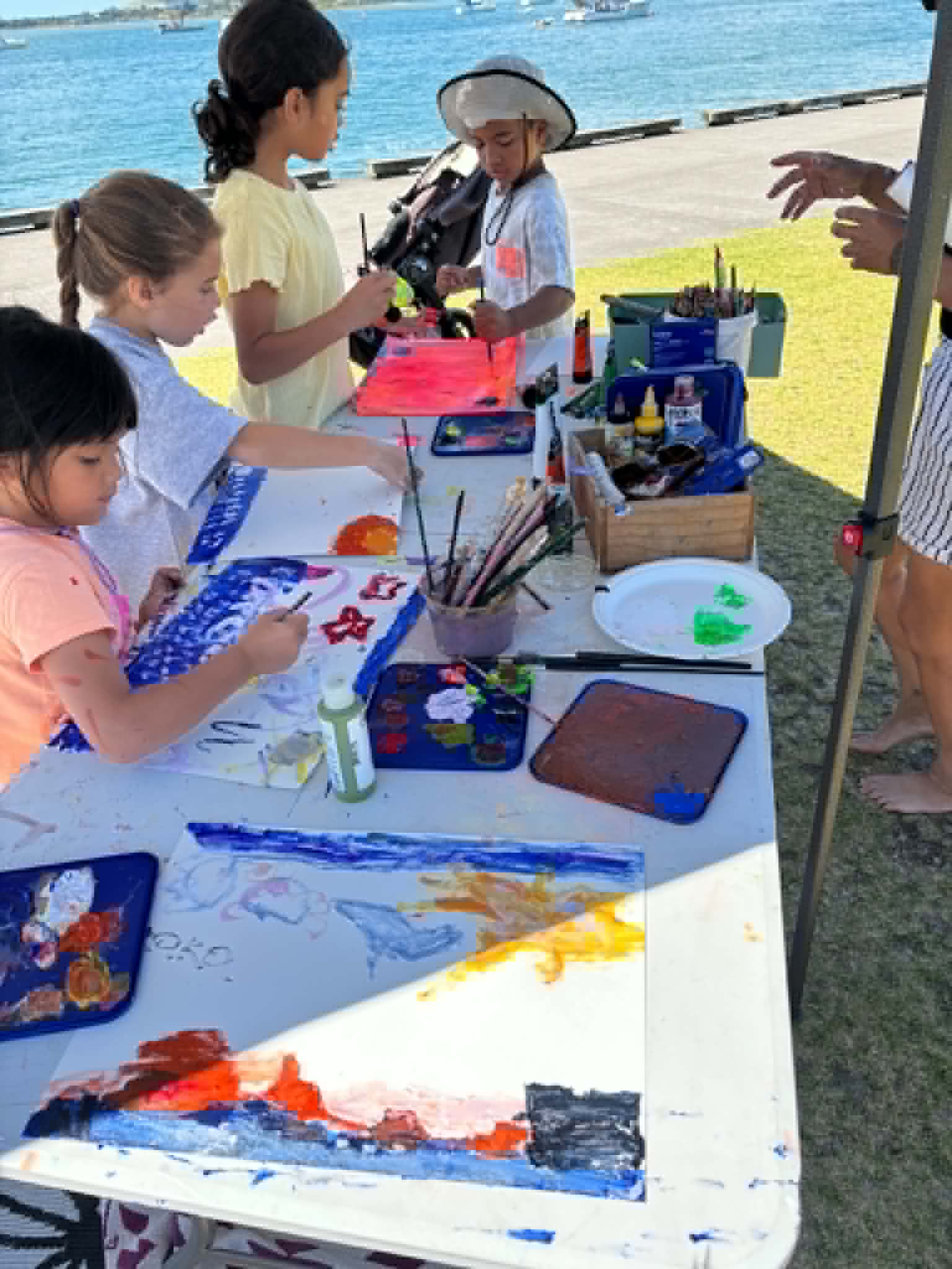 Artist painting by the water with Mount Maunganui in the background